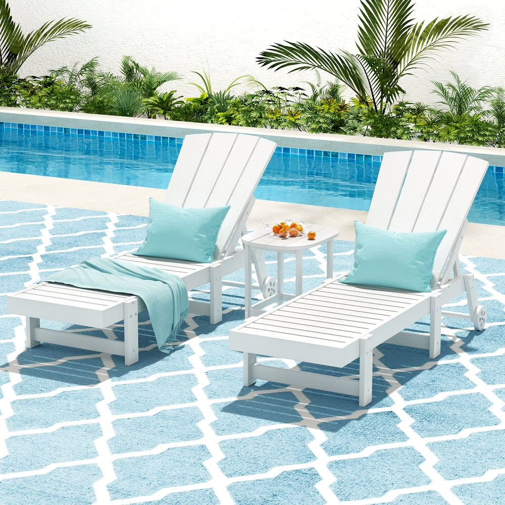 White lounge chairs with blue cushions by a poolside