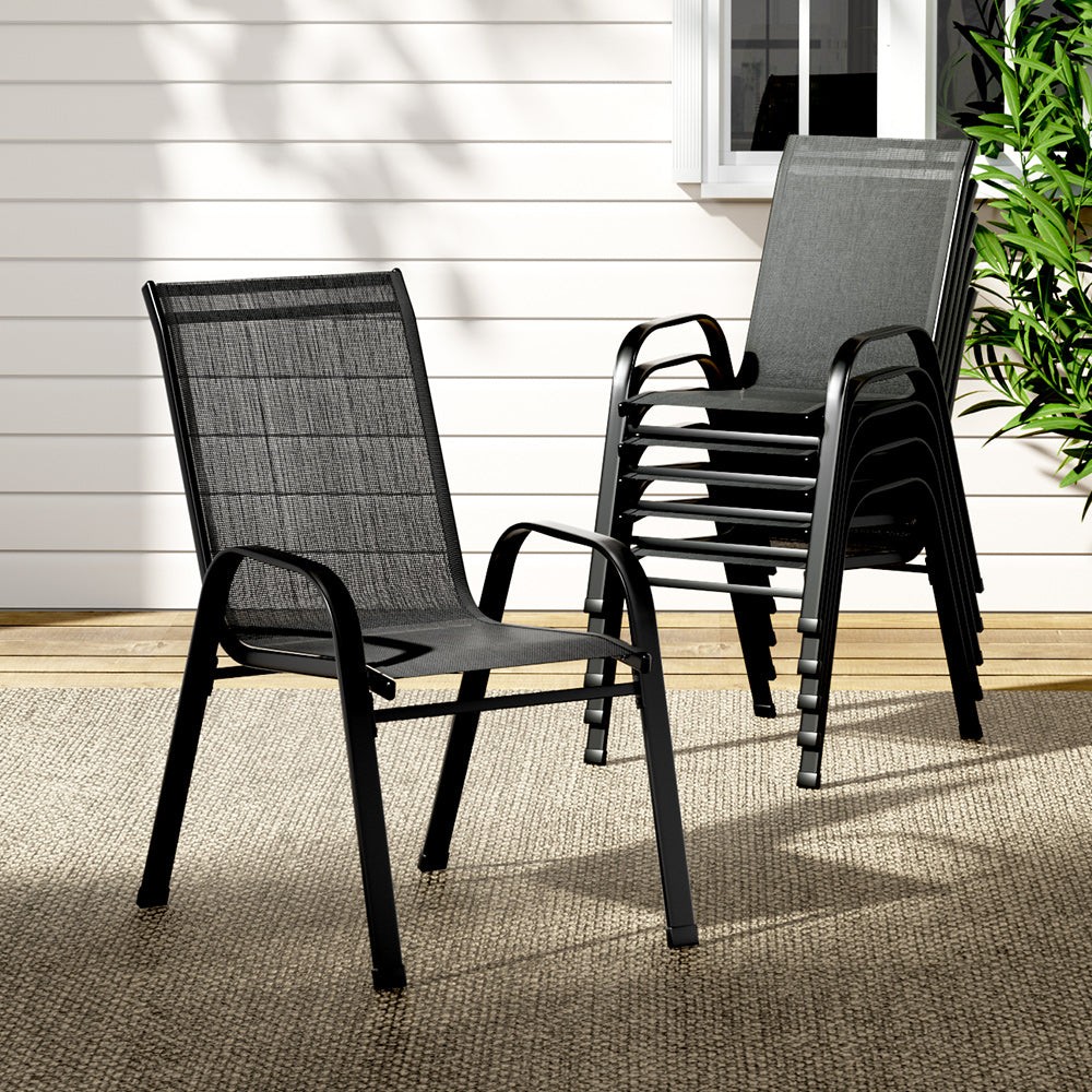 Two black outdoor chairs on a patio with a neutral background