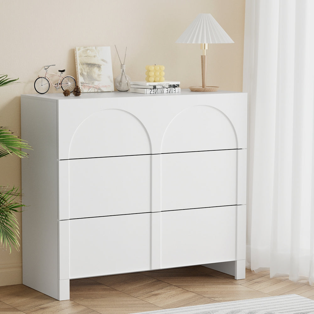 White dresser with decorative items in a room setting