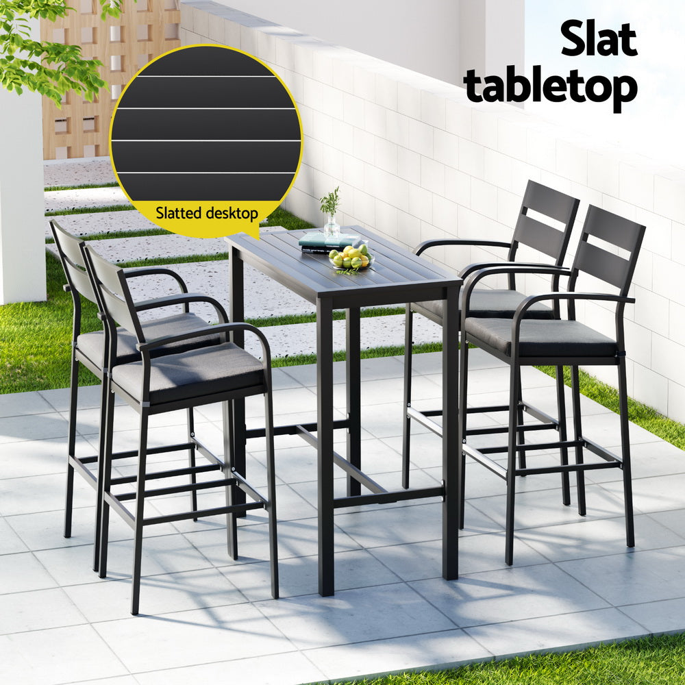 Outdoor patio set with high table and chairs on a patio area.