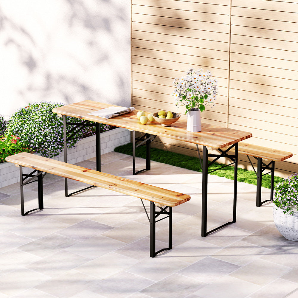 Outdoor patio set with wooden table and benches on a patio.