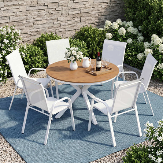 Outdoor patio set with a round wooden table and four white chairs on a blue rug.