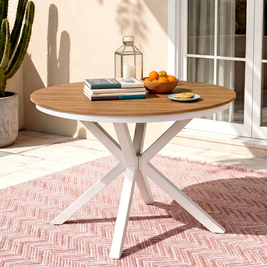 Round wooden table with white metal legs on a patio with a cactus and books in the background.