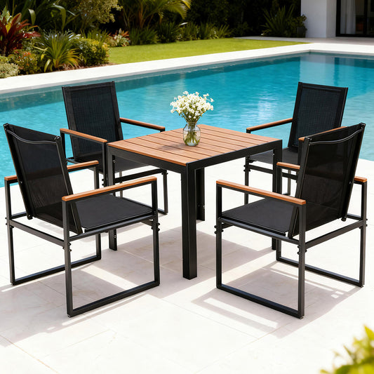 Outdoor patio set with wooden table and black chairs by a pool