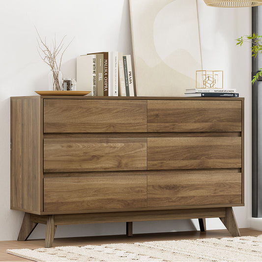 Wooden dresser with books and decor items in a room setting