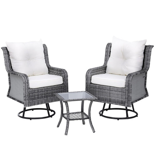 Two wicker chairs with white cushions and a matching table on a white background